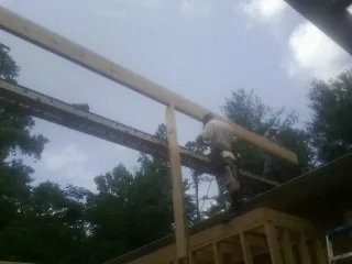 Carpenter setting a ridge beam over a new addition frame — Ice Dam Removal by Roofing Brothers in Ecru