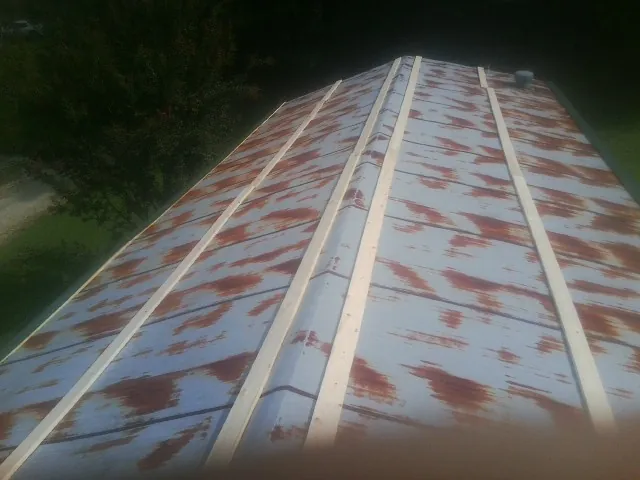 Rusted metal roof panels with new wood purlins before replacement — Storm Damage Roof Repair in Ecru by Roofing Brothers