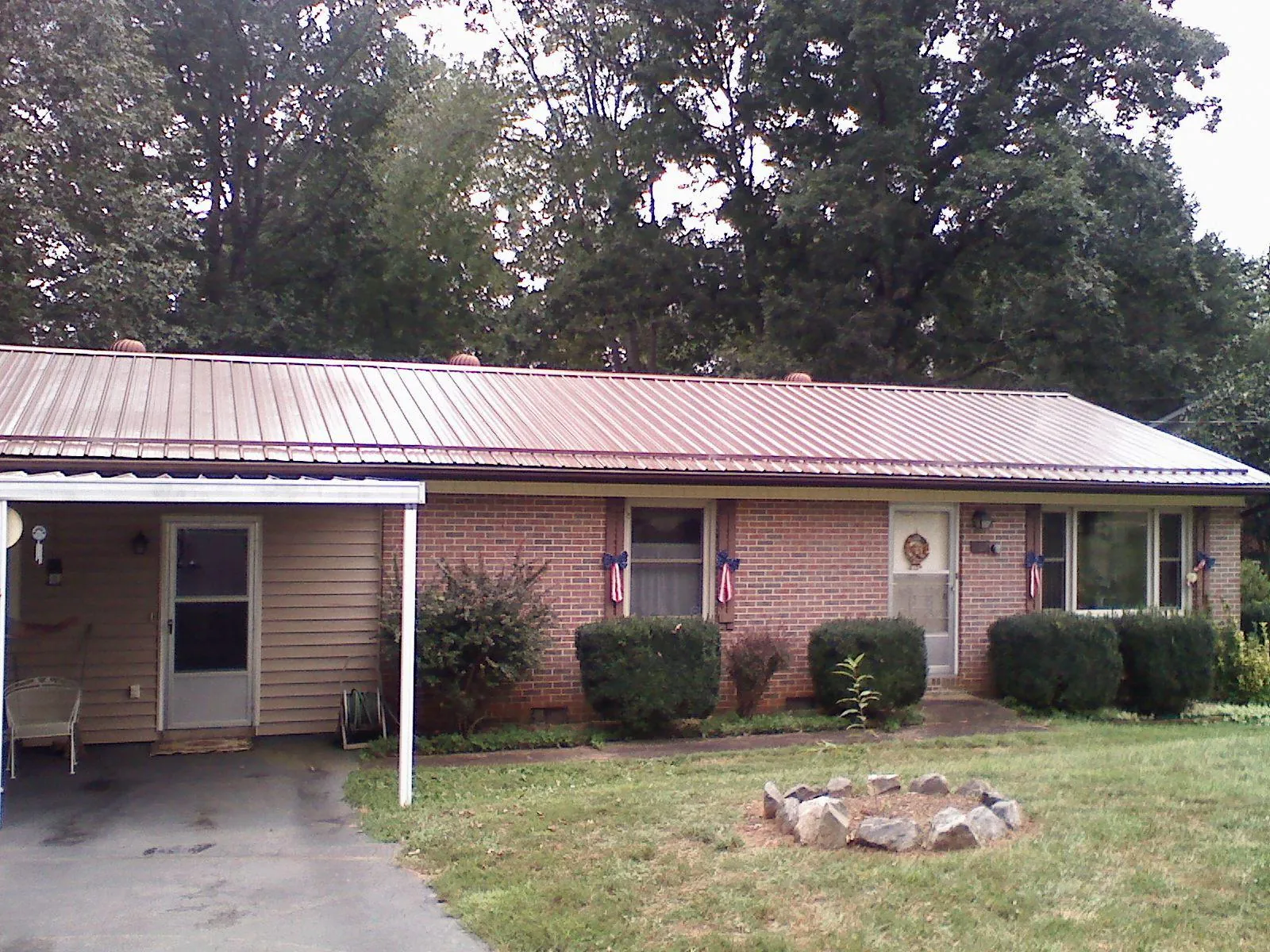 Bronze metal roof and carport on a brick ranch home — Roof Repair work by our crew in Ecru